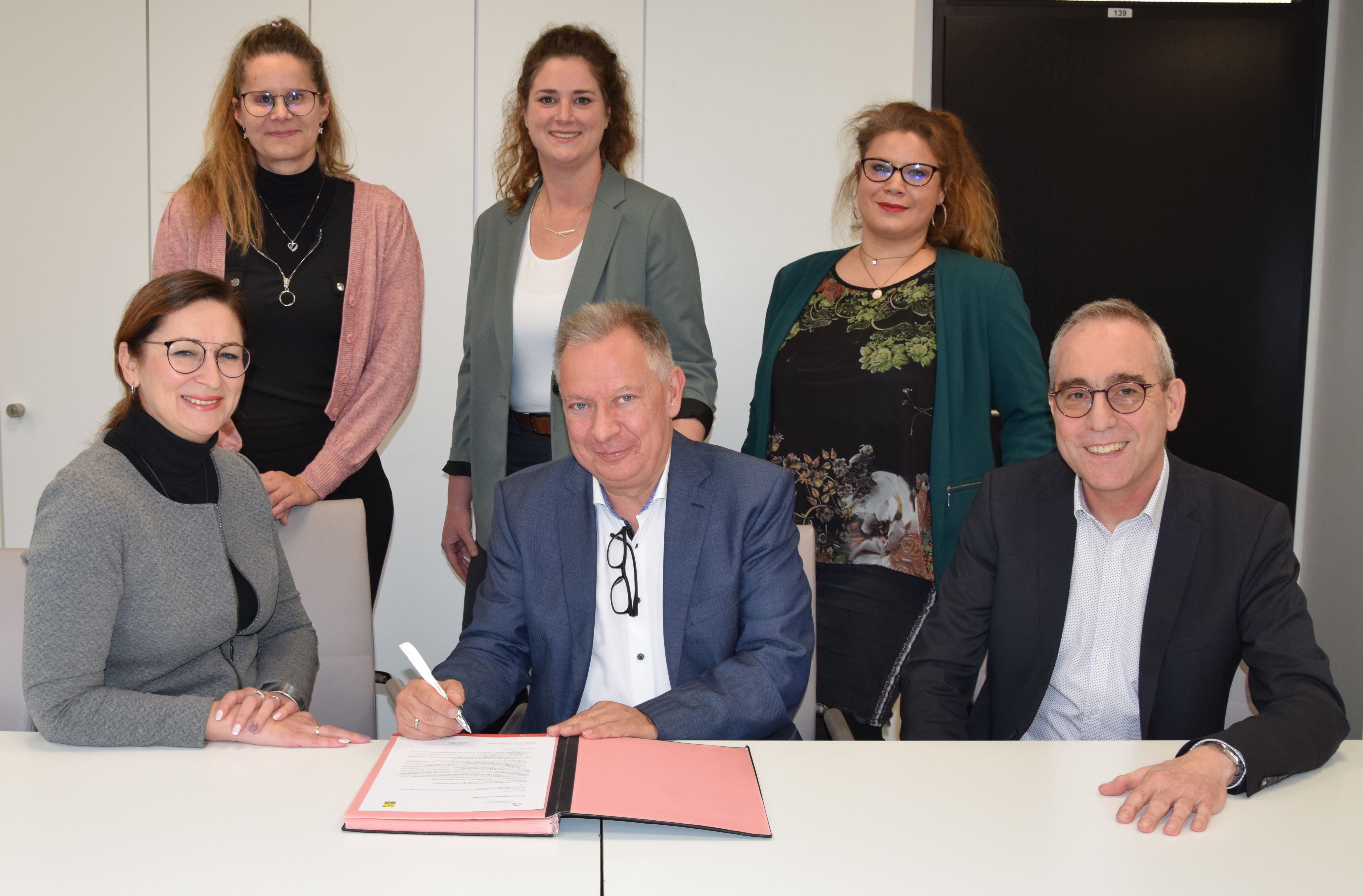 Landrat Stephan Pusch unterschreibt die Kooperationsvereinbarung (vorne Mitte) mit Personalamtsleiter Frank Steigner (vorne rechts) und Vertreterinnen des Berufsförderungswerkes Düren